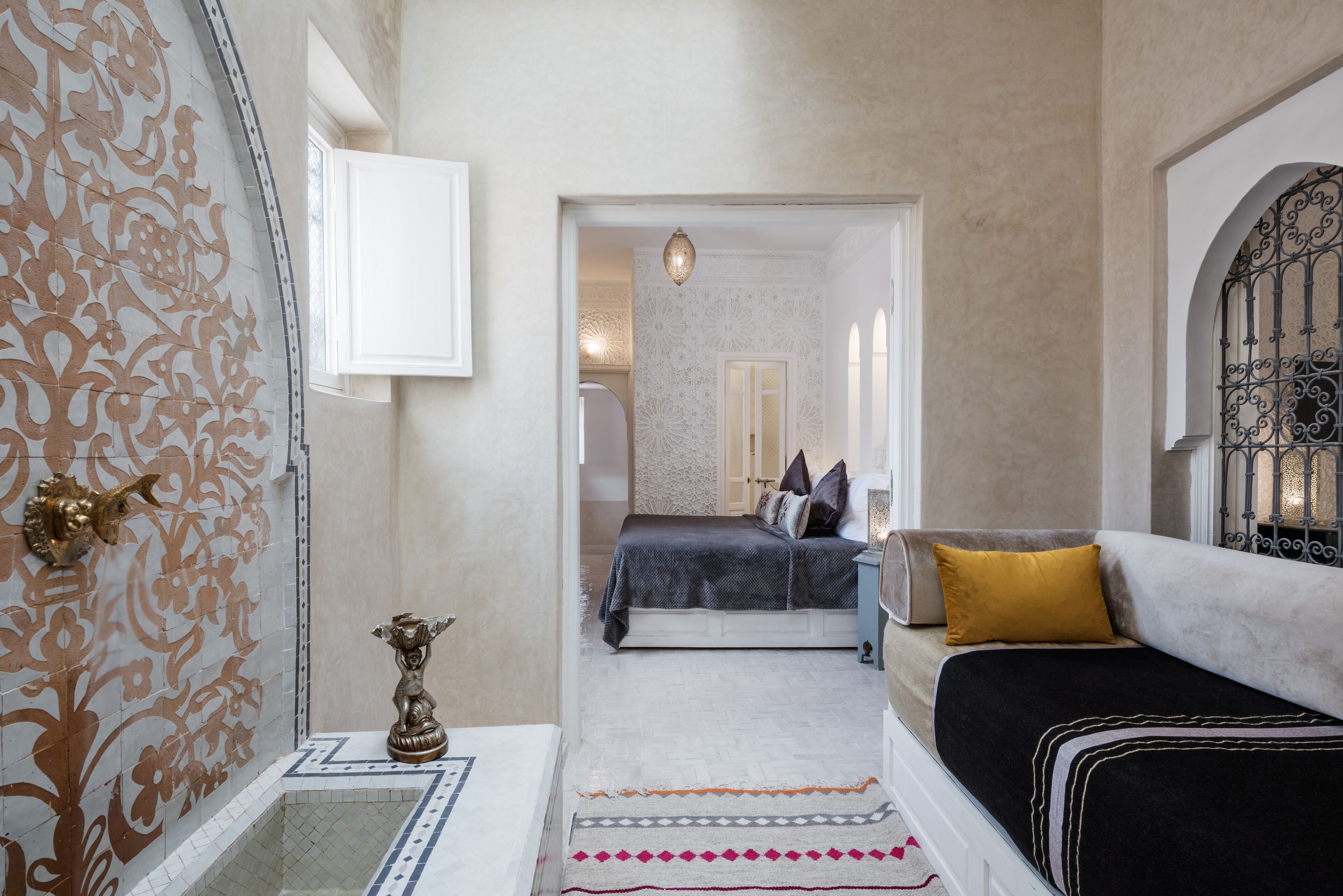 Une chambre à coucher comprenant un lit, un canapé, un mur décoratif et une petite table avec une lampe.