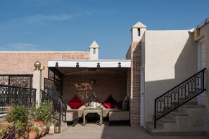A courtyard with a seating area, a table with drinks, and a staircase. - Riad Spice by Marrakech Riad (Marrakech)