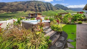 Ein Wohnhaus mit Swimmingpool, üppigem Garten und Blick auf die Berge.