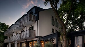 A modern multi-story building with balconies, outdoor seating, and potted plants. - M2 Resort Wellness & Spa (Wladyslawowo)