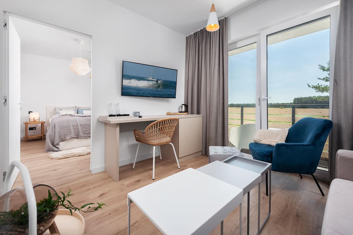 Une chambre d’hôtel moderne équipée d’un lit, d’un bureau et d’un coin salon.