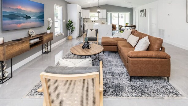 Una sala de estar moderna con sofá, mesa de centro y televisor.