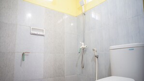 A bathroom with a toilet, a shower, and a hand dryer.
