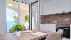 A modern kitchen with white cabinets, a wooden countertop, and a built-in oven. - Bella Vista Dalmatien #1 (Celina)