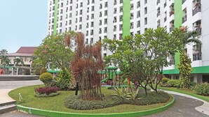 A residential building with multiple balconies, a playground, and landscaped gardens. - Capital O 92971 Pelangi Residence (South Tangerang)