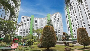 A residential complex with high-rise buildings, a playground with a red slide, and well-maintained gardens. - Capital O 92971 Pelangi Residence (South Tangerang)