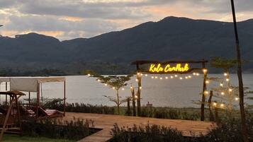 Une terrasse en bois ornée d’un panneau néon sur lequel on peut lire « Kala Camppark » et de guirlandes lumineuses.