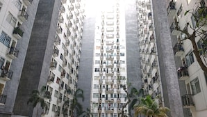 A high-rise residential building with multiple balconies, a central core, and surrounding palm trees. - Collection O 92981 Apartemen The Jarrdin By Gold Suites PropertyNearSTEI ITB: Sekolah Teknik Elektro dan Informatika ITB (Bandung)