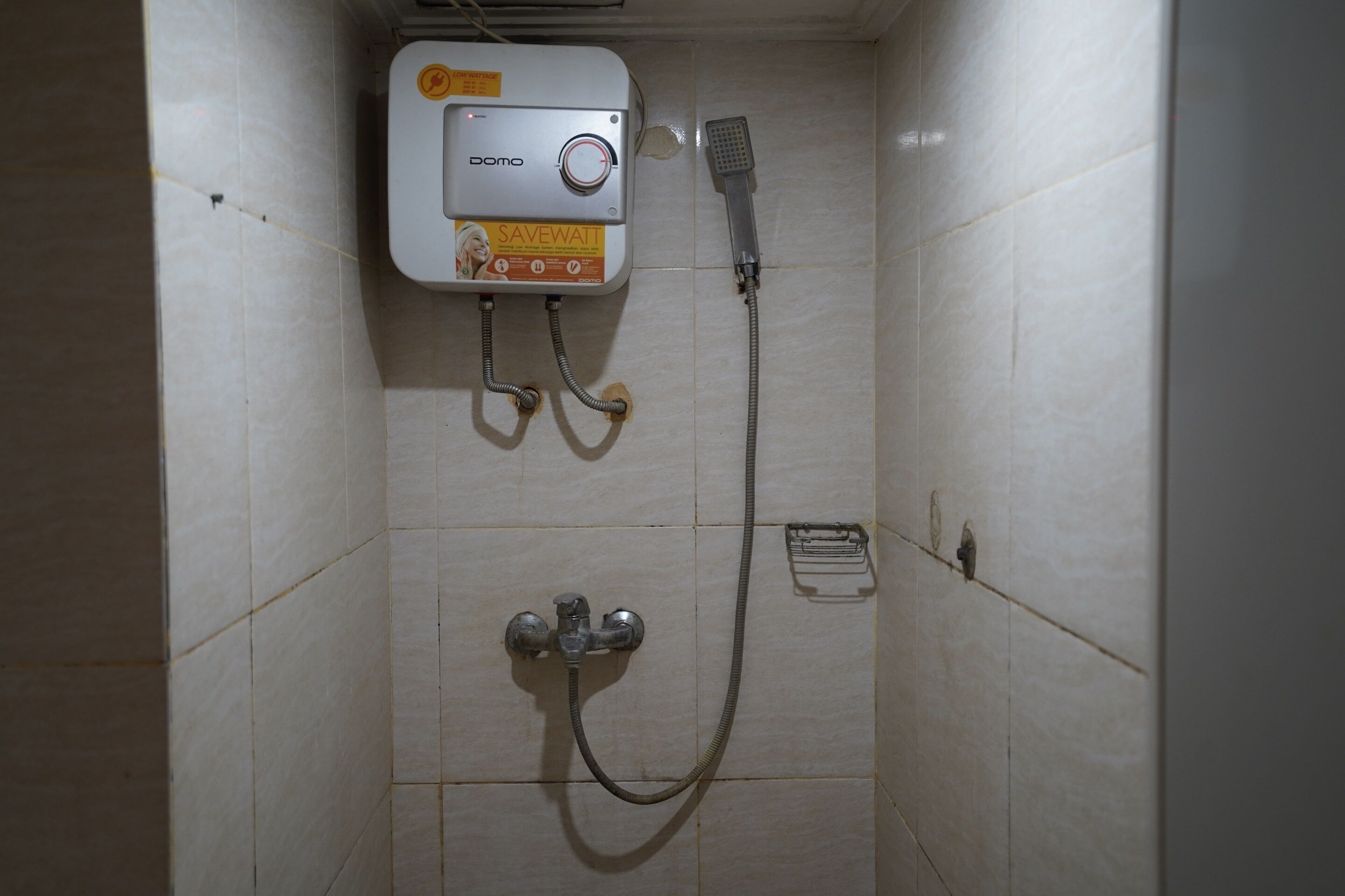 A shower area with a wall-mounted showerhead and a handheld shower attachment.