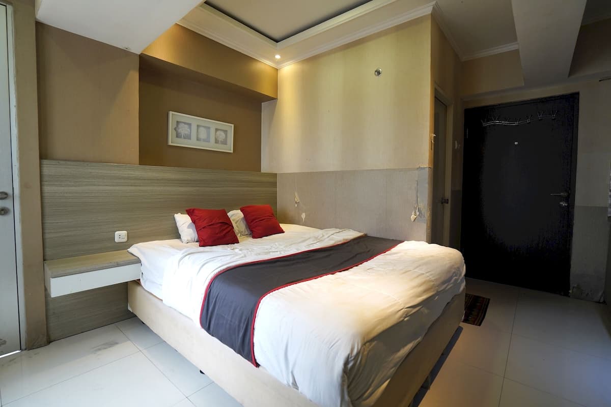 A bedroom with a bed, bedside table, and a door.