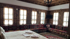Una camera tradizionale con un letto grande, un divano e una televisione.