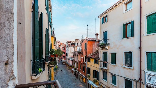 A narrow street flanked by buildings with balconies and shutters. - Lovely 1-bed Apartment in Venezia (Venice)