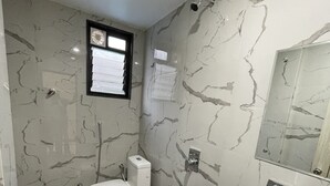 A bathroom with a toilet, sink, and mirror. - Hotel Rajdhani (Latur)