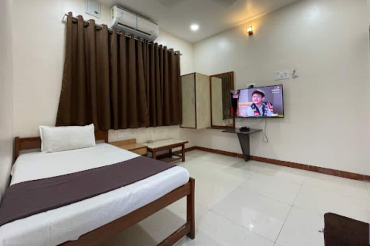Une chambre d’hôtel équipée d’un lit, d’un bureau, d’une télévision et d’un appareil de climatisation.
