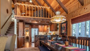 A spacious kitchen with wooden cabinets, a large island, and a dining area with a bench and chairs. - Sukoon Retreat - Free Summer Pool Access! (Dorrington)