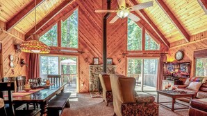 A spacious wooden cabin with a high ceiling, large windows, a dining area, and a cozy living room. - Sukoon Retreat - Free Summer Pool Access! (Dorrington)