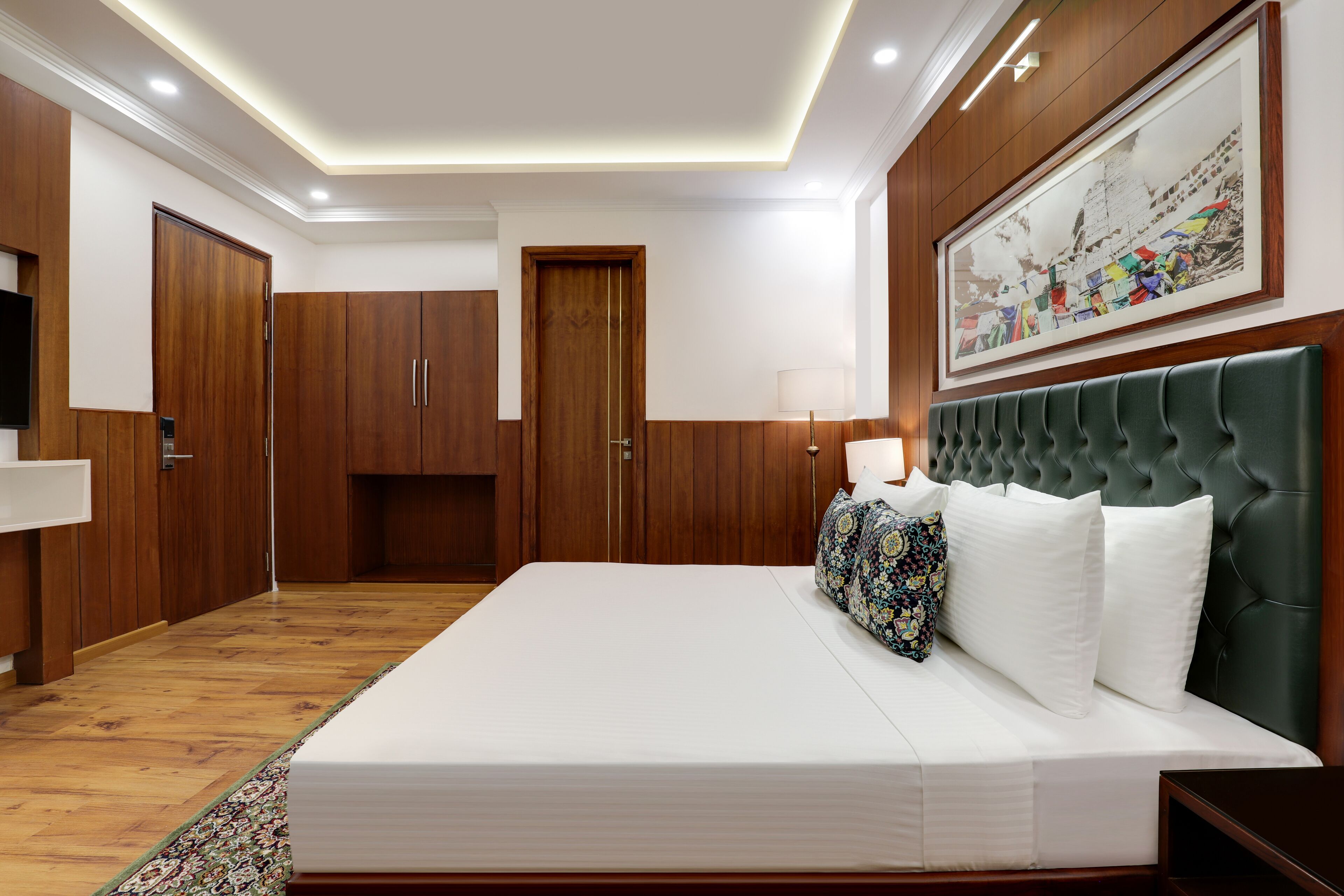 Un dormitorio moderno con una cama grande, un armario de madera y un cuadro enmarcado en la pared.
