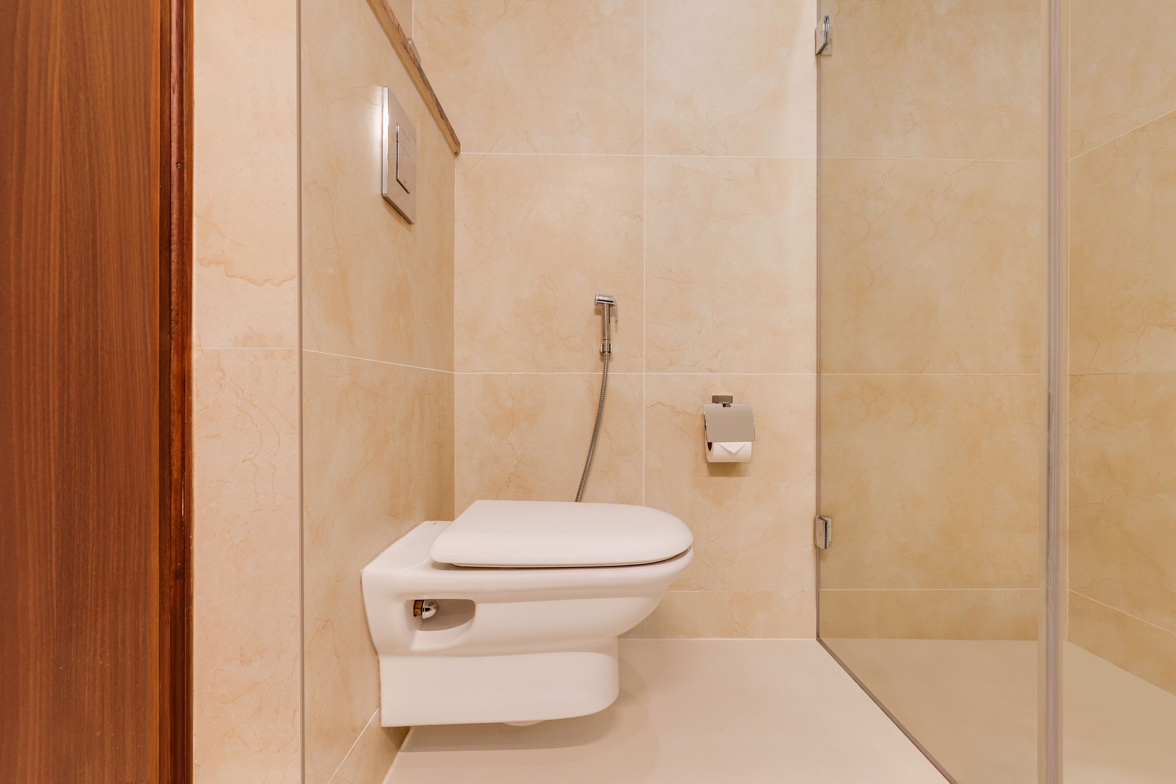 Un baño moderno con inodoro, ducha y puerta de madera.