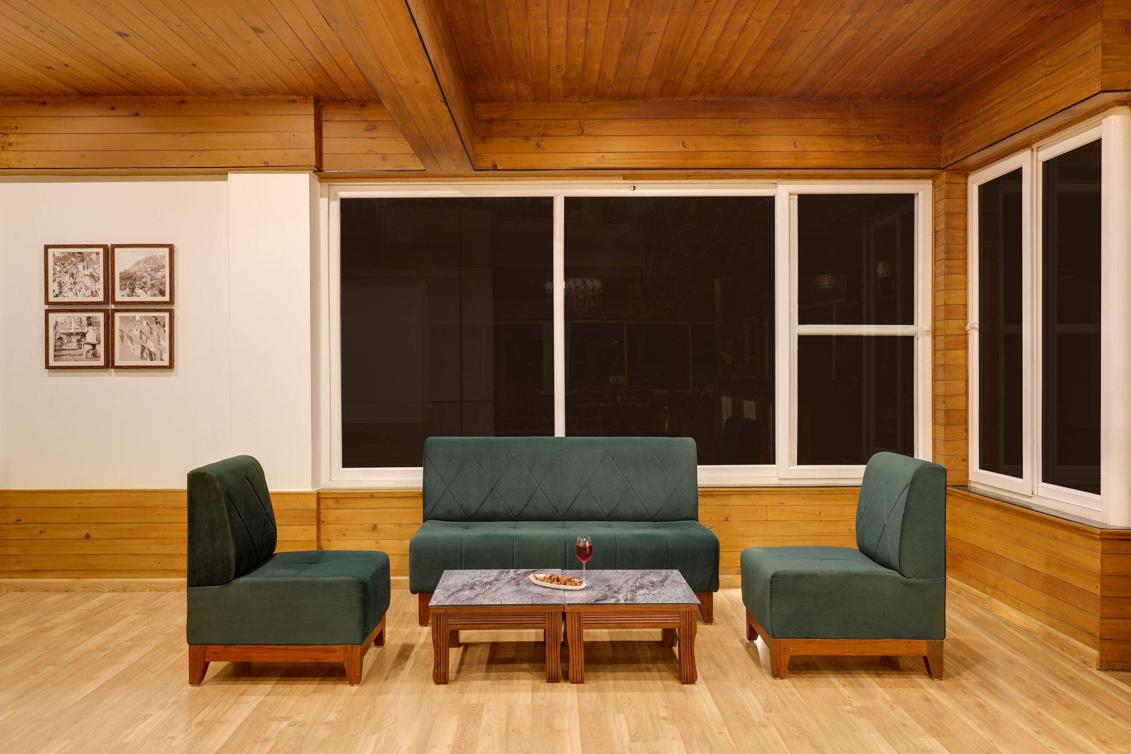 A cozy room with a green sofa, two matching armchairs, and a wooden coffee table.