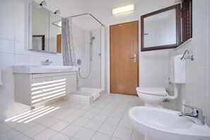 Een douche, een haardroger, een bidet, handdoeken