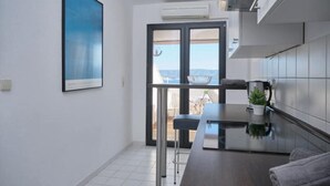 Una cucina moderna con un'ampia finestra, un piano di lavoro scuro e vista sull'esterno.