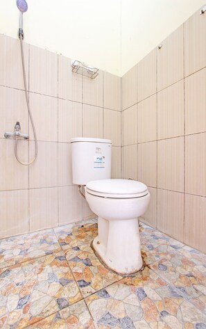 A bathroom with a toilet, a shower, and tiled walls.