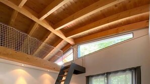 A bedroom with a bed, a staircase, and a window.