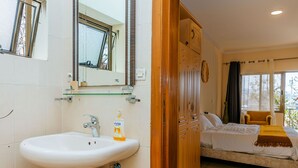A bathroom with a sink, mirror, and wooden wardrobe. - Stunning 3-bed House in Kigali (Kigali)