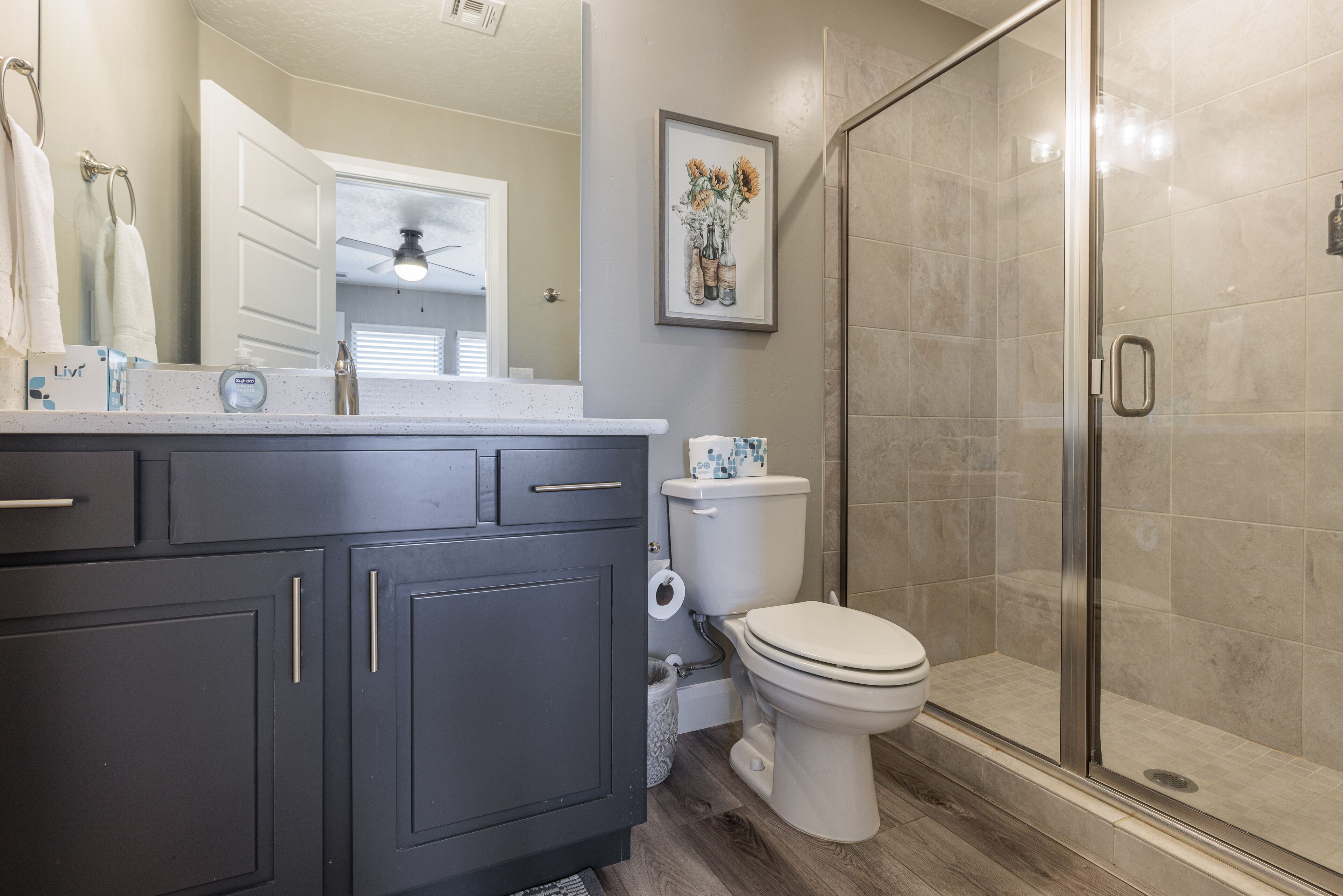 Un baño moderno con ducha, inodoro y tocador.