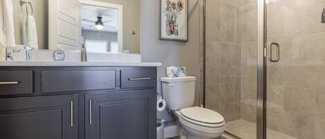 Un baño moderno con ducha, inodoro y tocador.