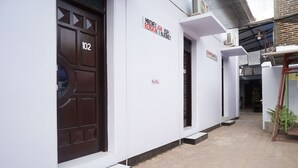 A building with a brown door labeled "102" and a sign reading "MRENEO ADA RENGAK N JEBRET". - Hotel O Trisna Patihan Resort (Tulungagung)