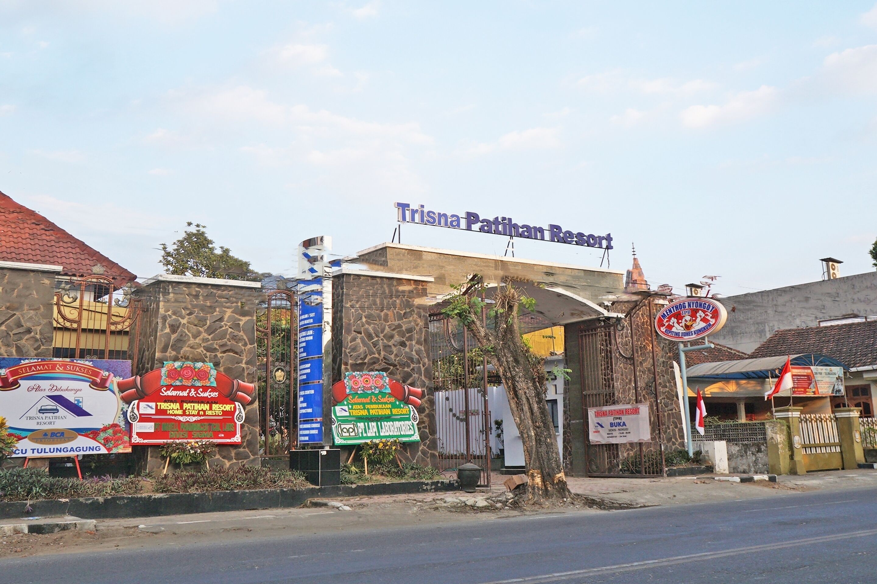 A building with a sign for Trisna Patiham Resort.