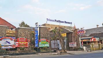 A building with a sign for Trisna Patiham Resort.