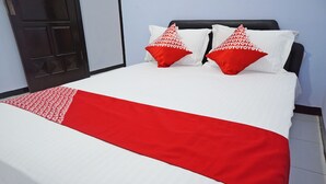 A neatly made bed with a white and red bedspread and matching pillows. - Hotel O Trisna Patihan Resort (Tulungagung)
