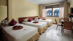 Une chambre d’hôtel avec deux lits, une table à manger et une chaise.