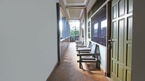 A corridor with benches and a door. - SPOT ON 92973 Madani Syariah Guesthouse (Praya)