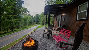A wooden cabin with a fire pit and outdoor seating.