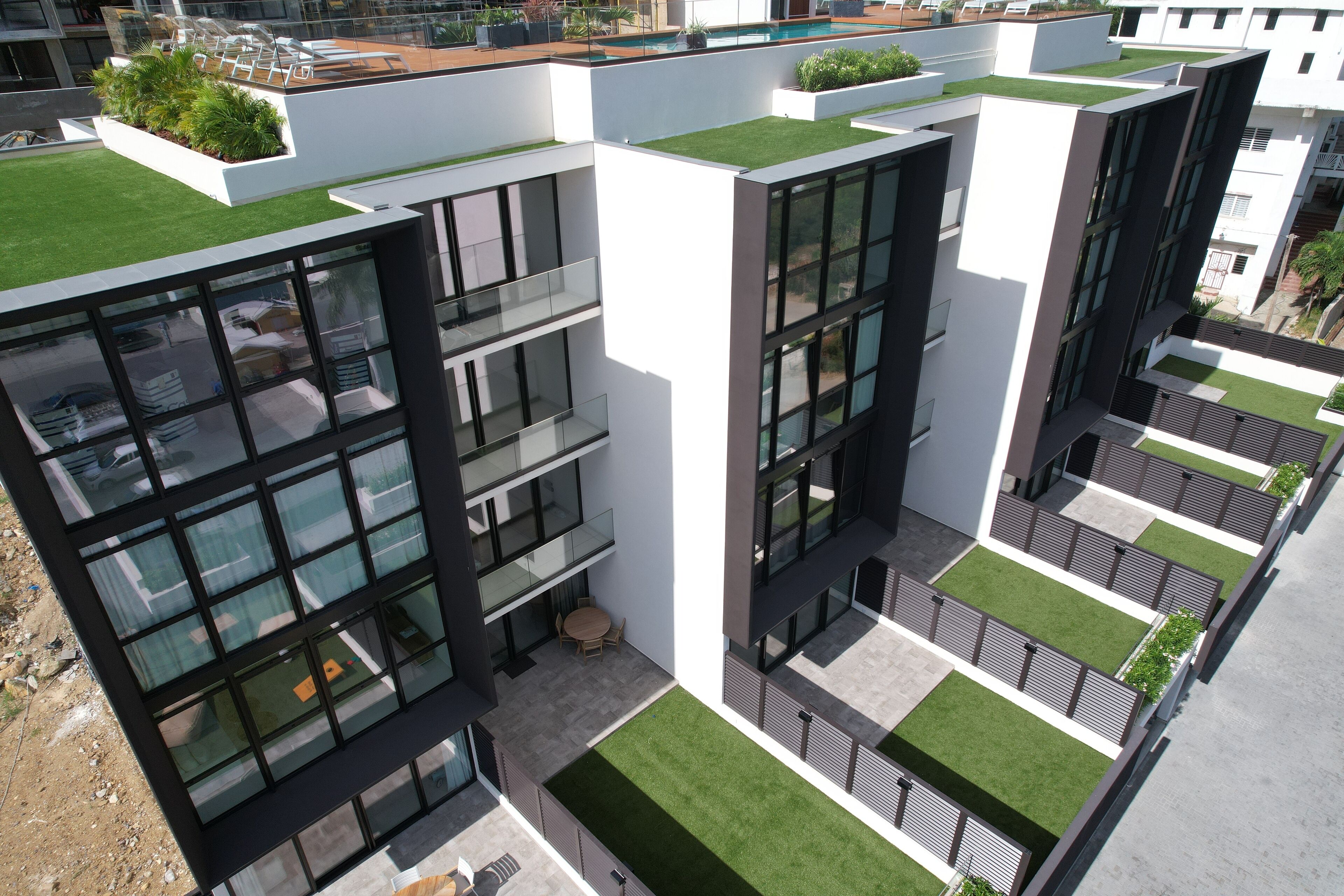 Een modern gebouw met meerdere balkons, groene daken en een binnentuin.