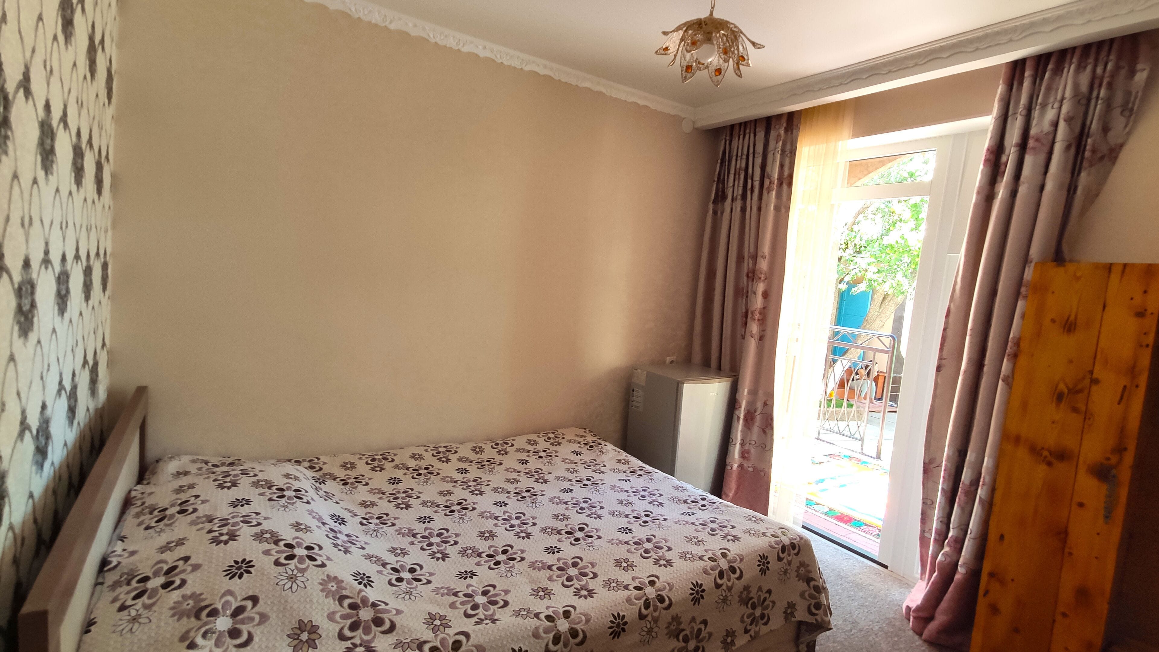 Un dormitorio con cama, armario y un escritorio pequeño.