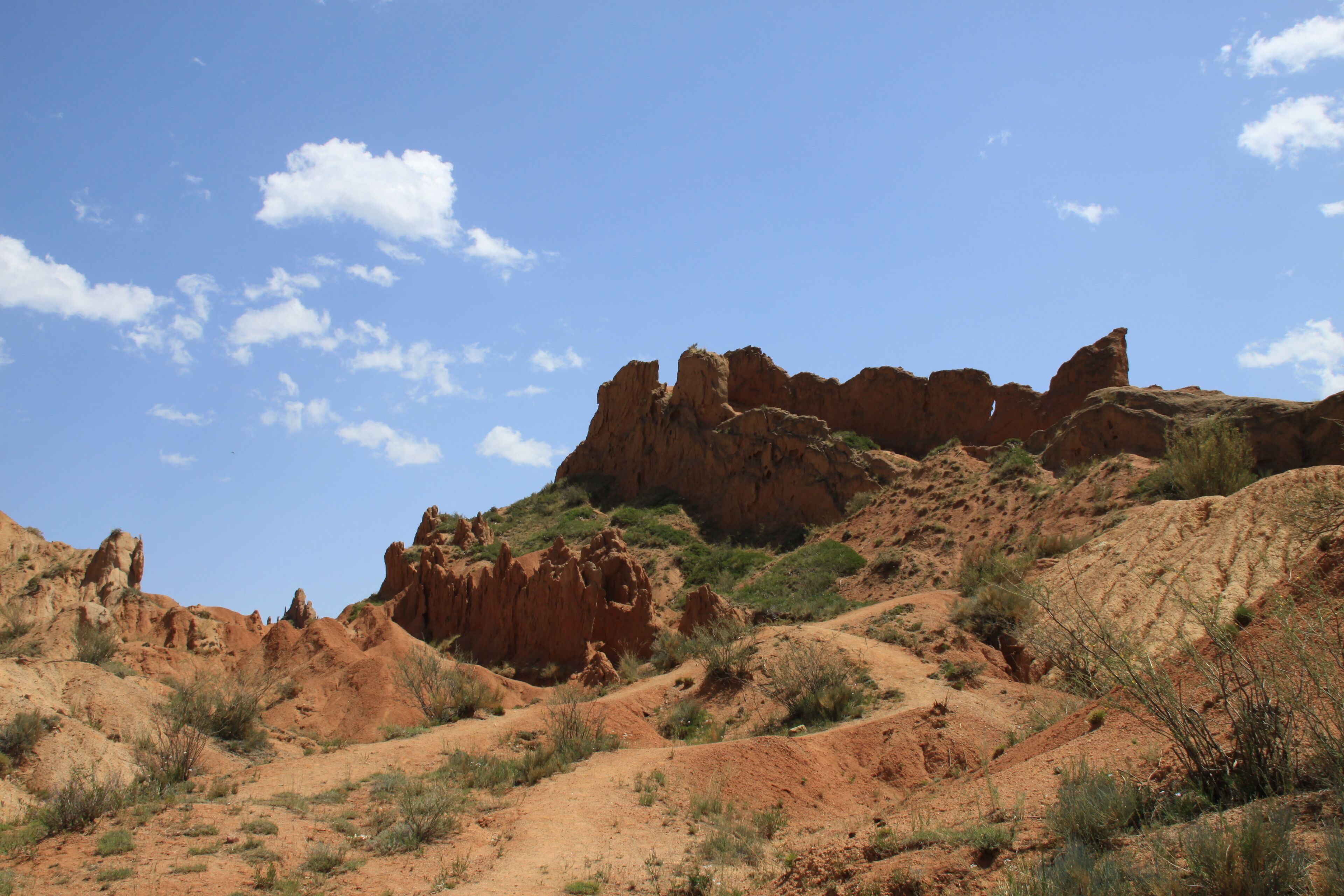 A desert landscape with rocky formations and sparse vegetation.