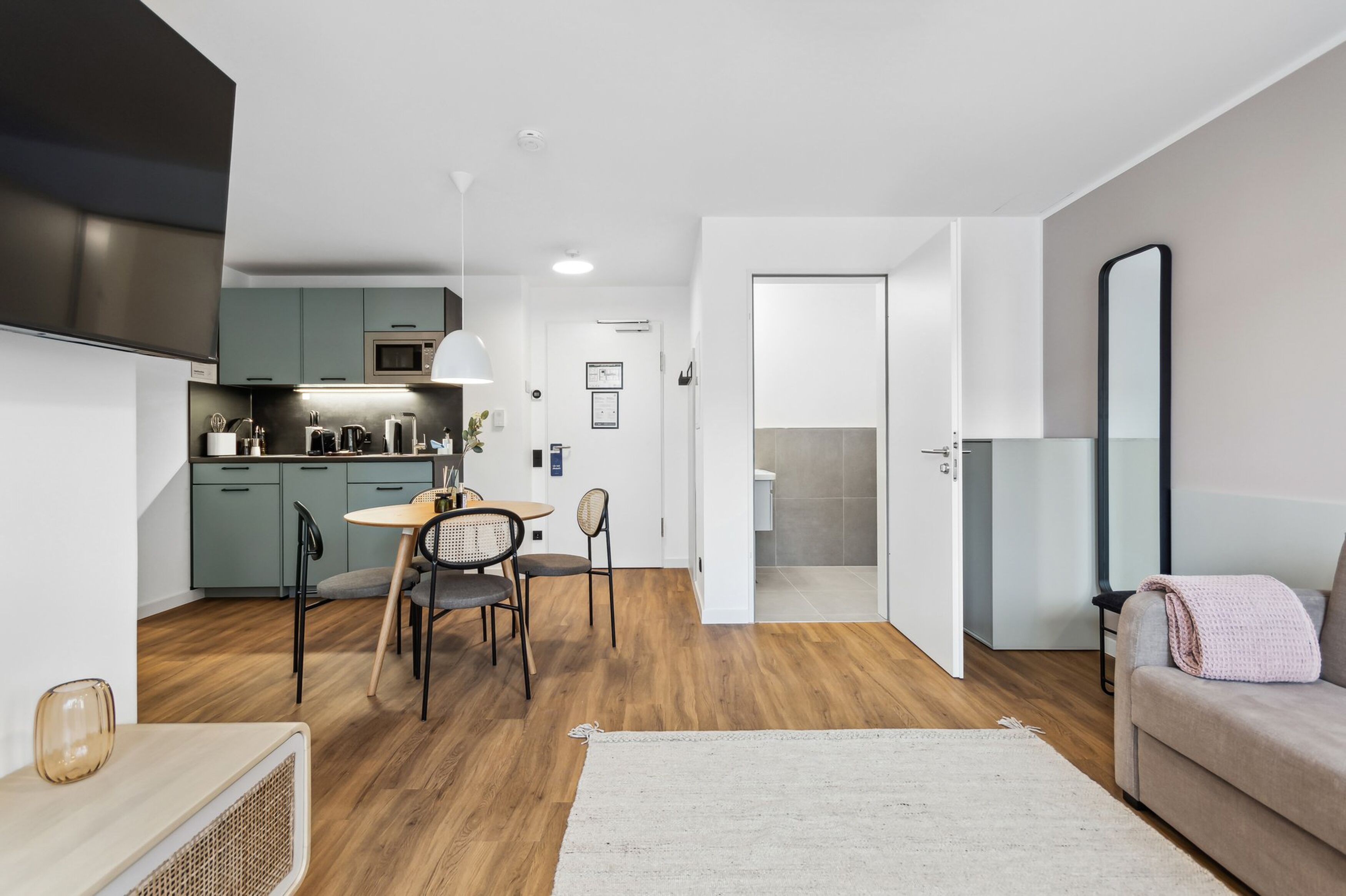 A modern apartment with a kitchen, dining area, and living room.