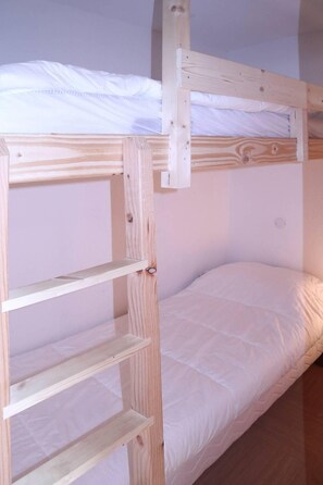A bunk bed with a wooden frame and white bedding. - Ski-in/ski-out & foot of the slopes, 2nd floor, swimming pool, sauna, balcony, tv, ski locker, 62m² (Les Orres)