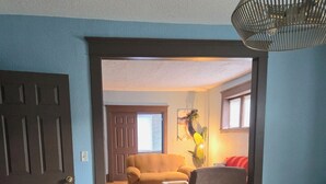 A room with a dining table set for two, a sofa, a chair, and a lamp. - Ana Maria del Azul DT Minneapolis US Bank Stadium (Minneapolis)