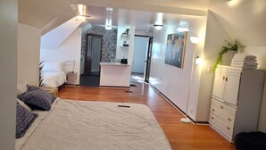 A bedroom with a bed, bedside table, and a desk area with a chair. - Ana Maria del Azul DT Minneapolis US Bank Stadium (Minneapolis)