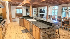 Una cocina amplia con armarios de madera, encimera de granito y una pared decorativa de piedra.