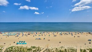 Een strand met veel parasols en mensen.