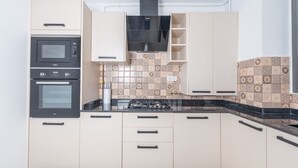Una cocina moderna con dos hornos, una estufa y armarios de colores claros.