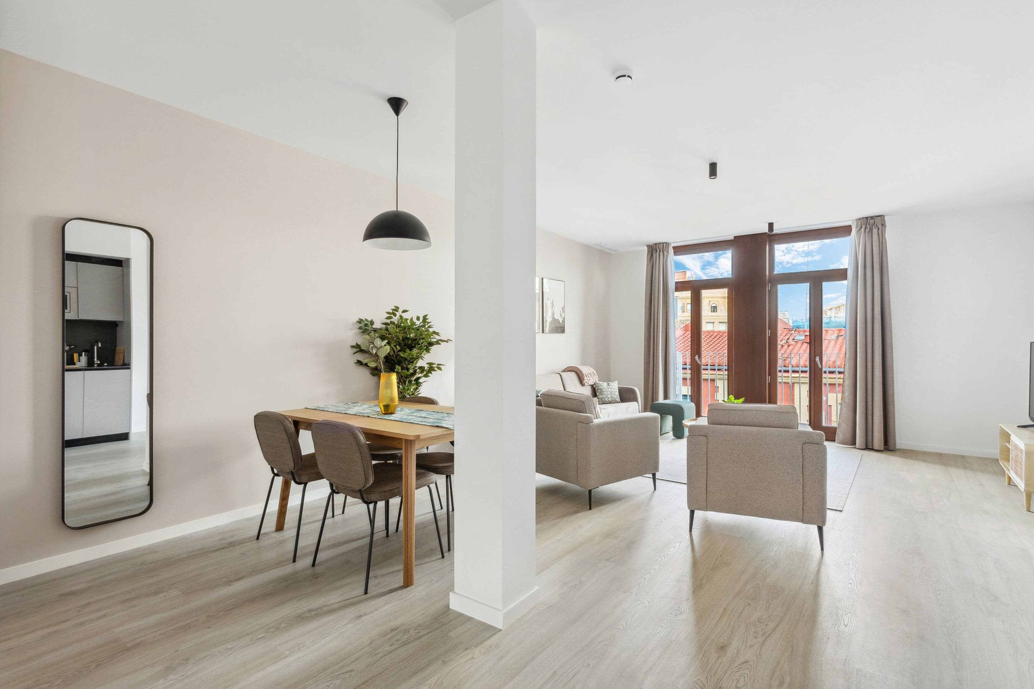 Un appartement moderne comprenant un coin repas, un salon et un balcon avec vue.