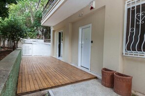 Guests enter through an entrance with a wooden deck and a small window with decorative iron bars.
