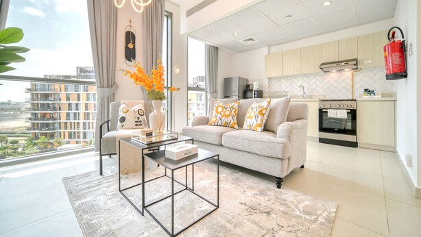 A modern living room with a sofa, coffee table, and a view of the city.